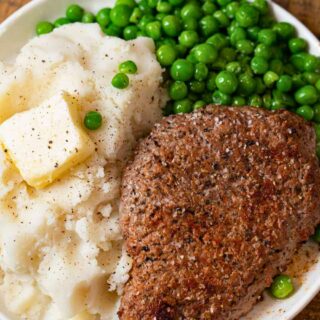 Cube steak plated with mashed potatoes and peas