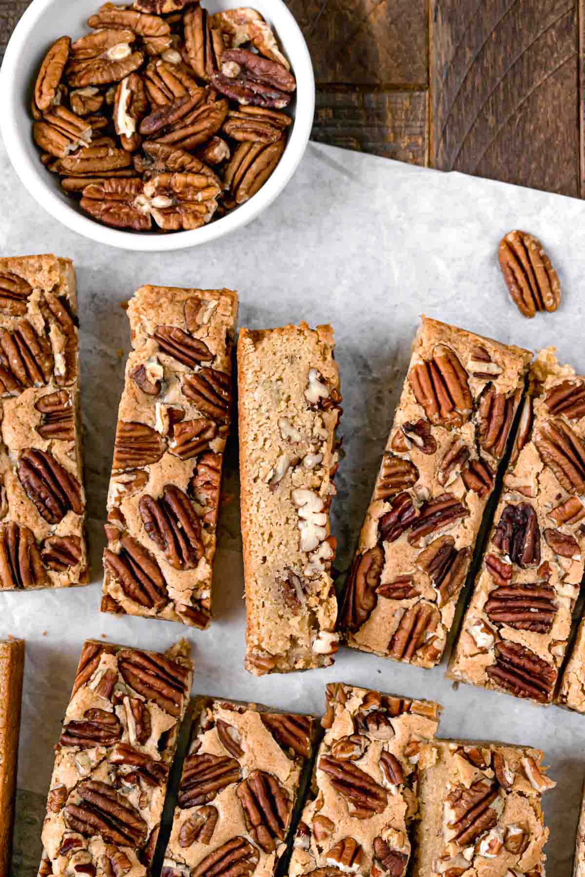 Maple Pecan Bars sliced and served on white parchment paper.