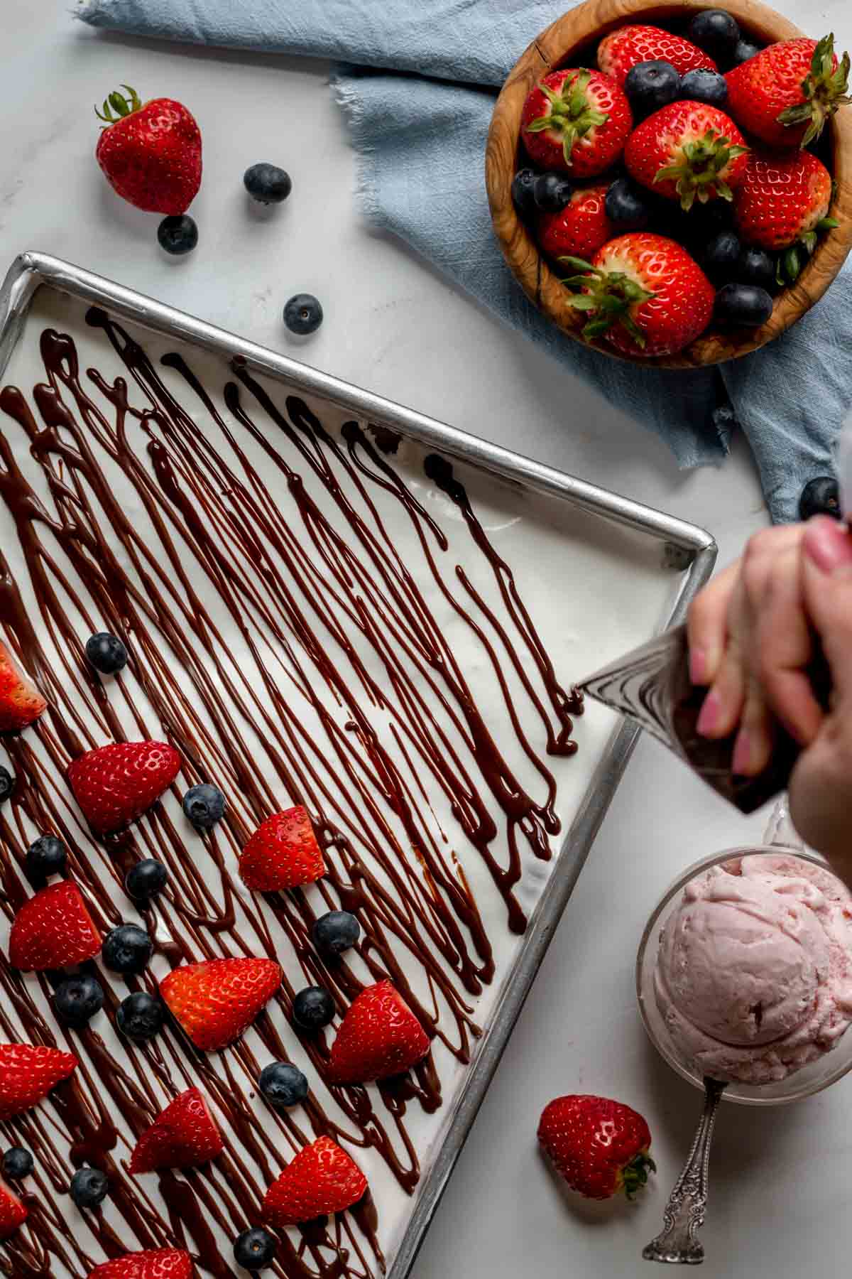 4th of July Ice Cream Casserole piping chocolate and layering berries on top