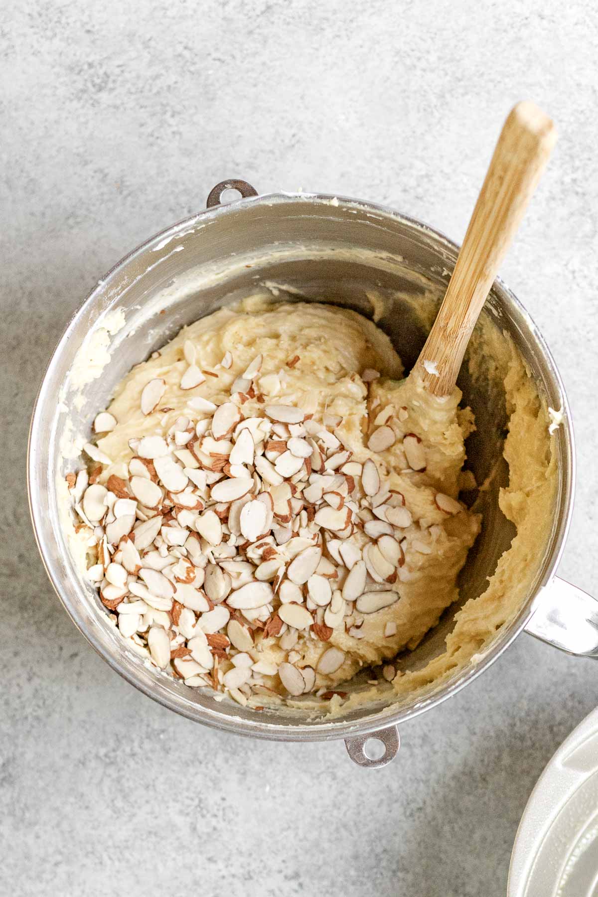 Almond Bundt Cake adding almonds to batter in mixing bowl