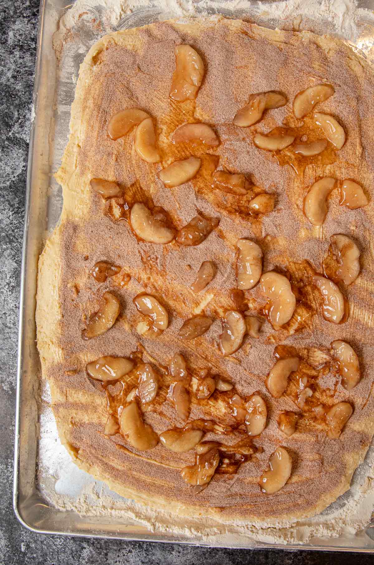 Apple Crisp Cinnamon Rolls rolled out dough topped with cinnamon and apples