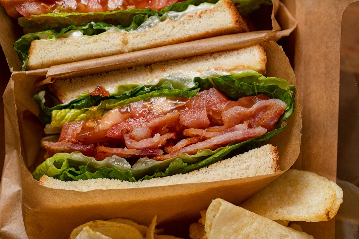 BLT Sandwich sliced in half with chips