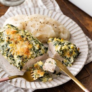 Baked Spinach Artichoke Chicken on plate with mashed potatoes