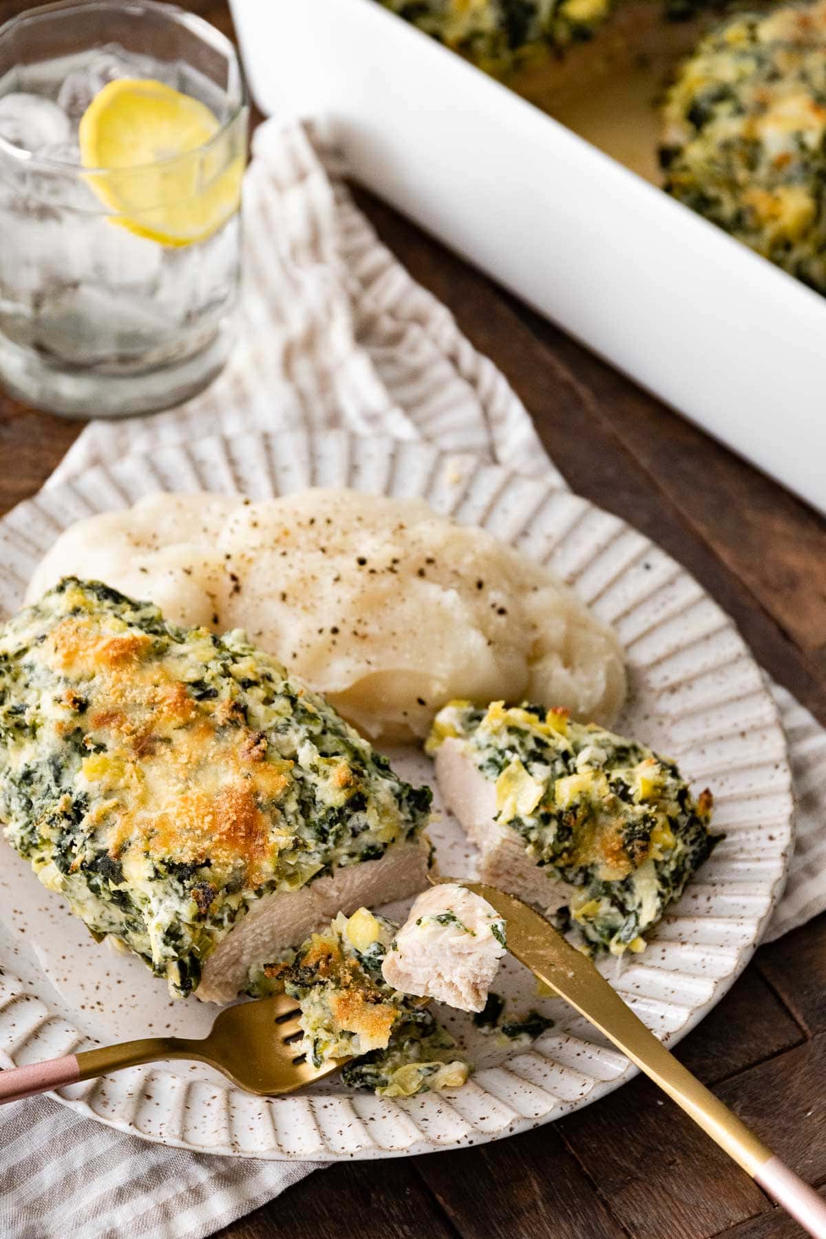 Baked Spinach Artichoke Chicken on plate with mashed potatoes