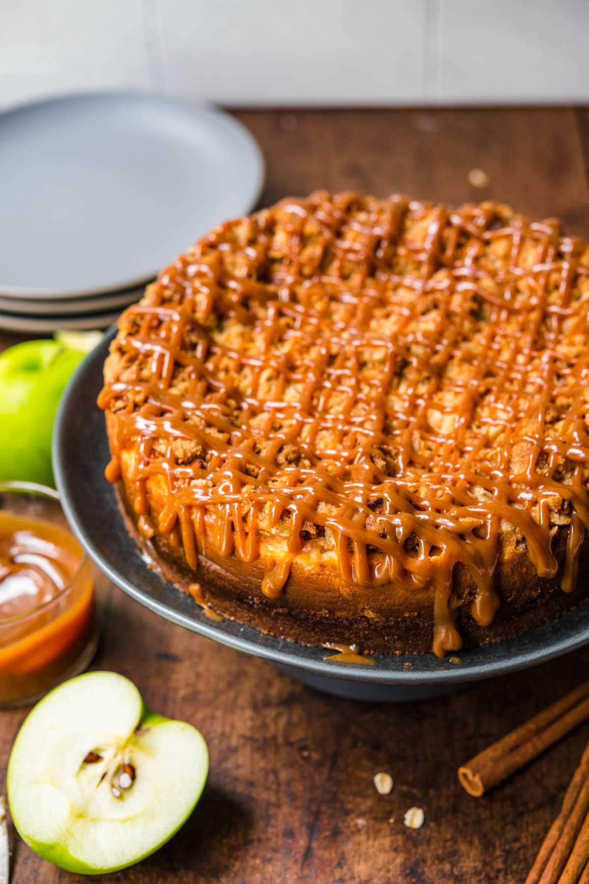 Caramel Apple Crumb Cheesecake on serving plate with caramel drizzle on top