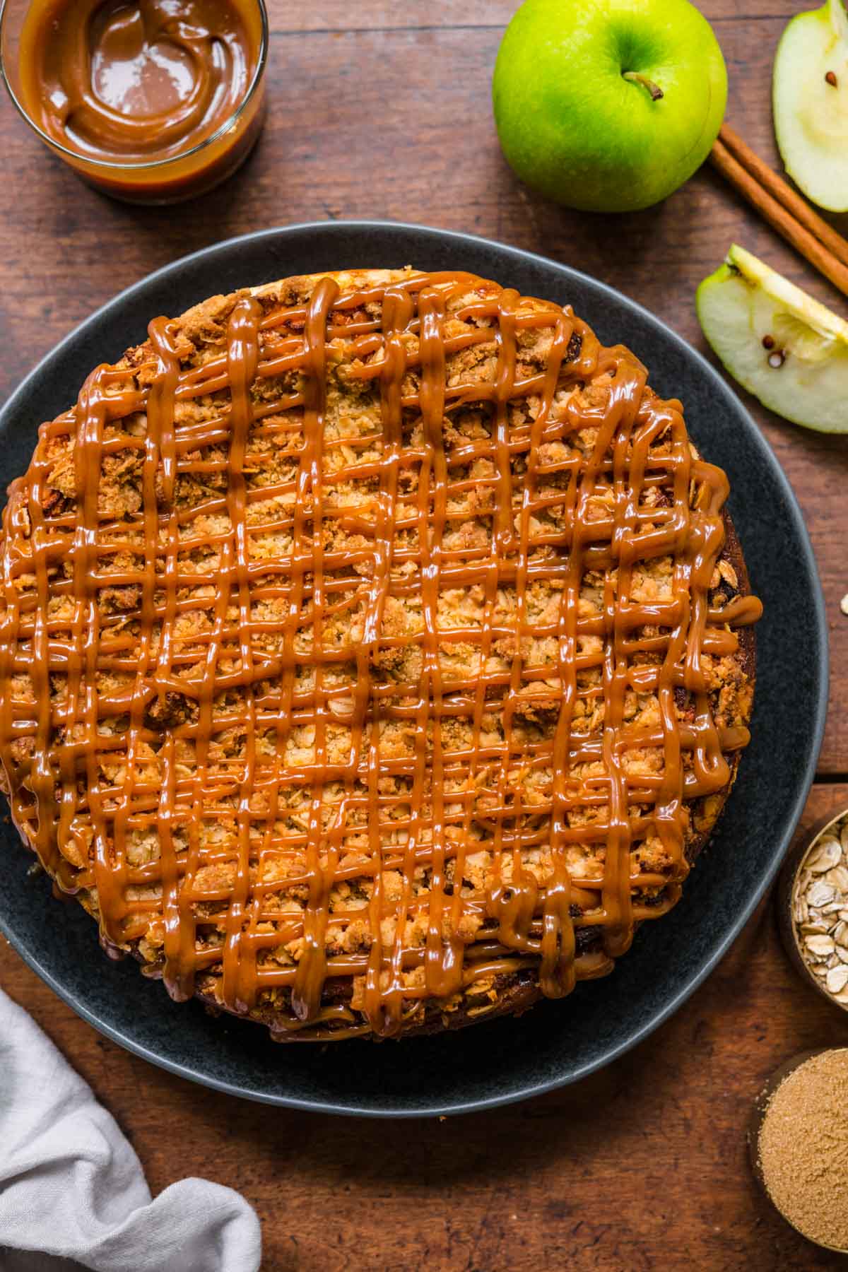 Caramel Apple Crumb Cheesecake on serving plate with caramel drizzle on top