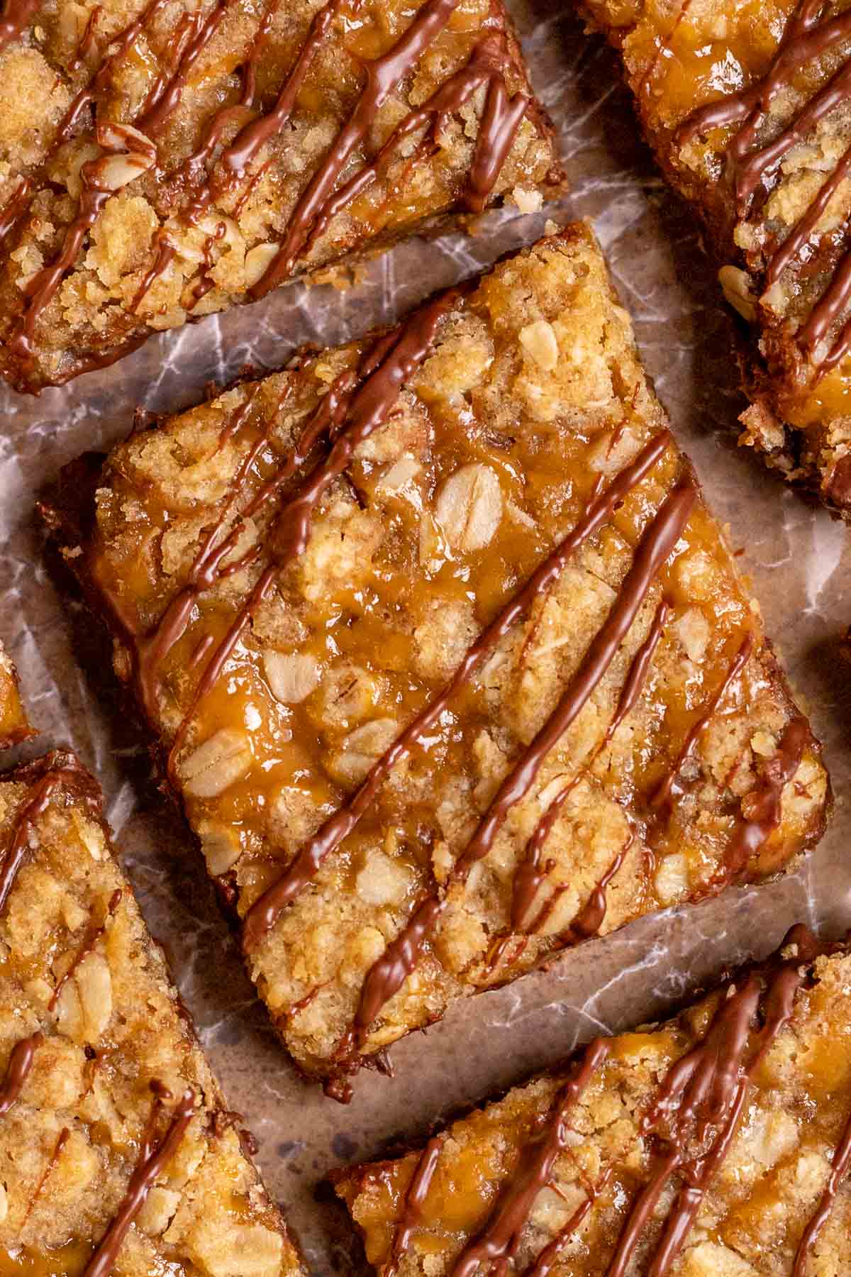 Caramel Chocolate Bars sliced on parchment drizzled with chocolate