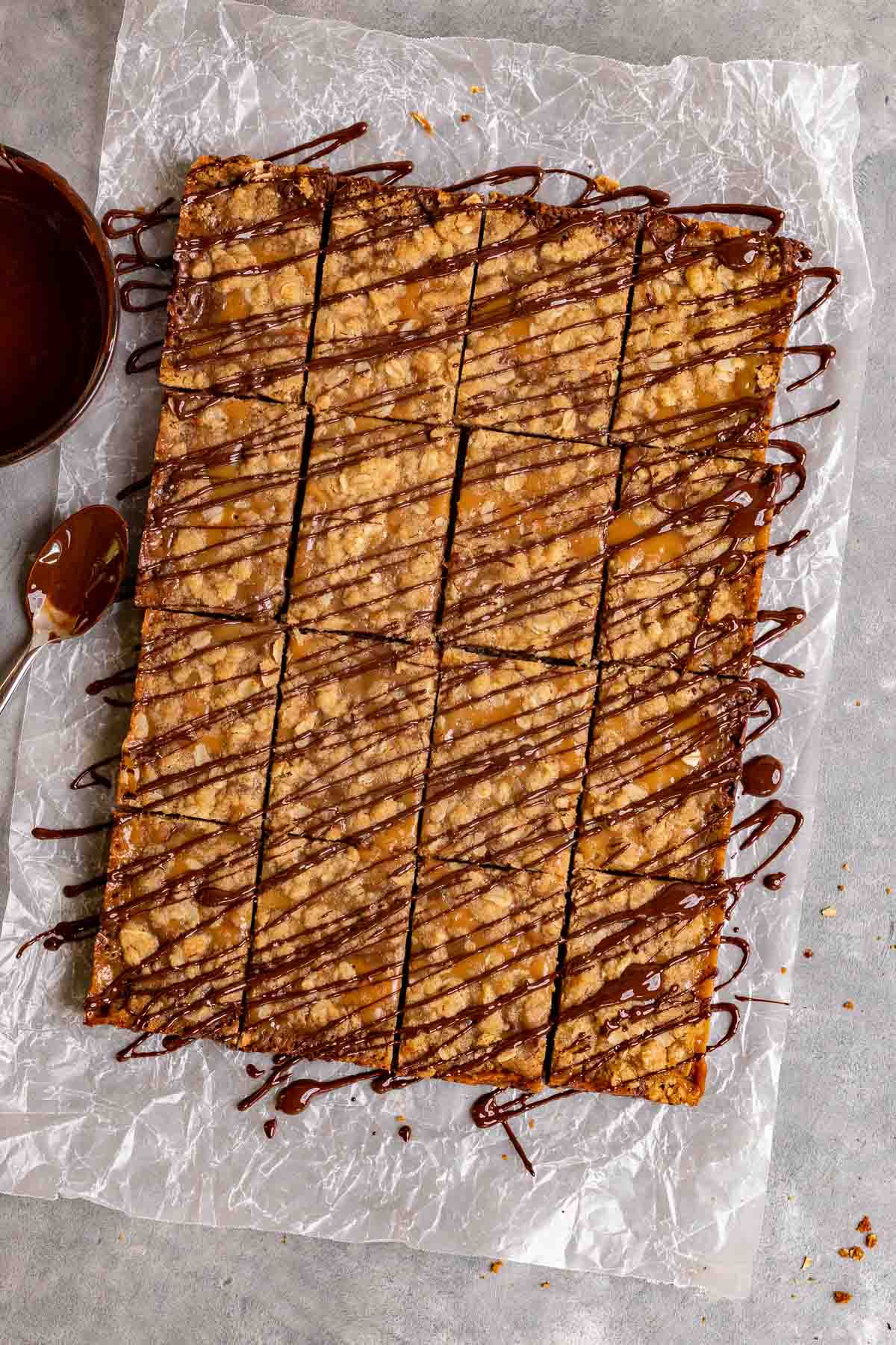 Caramel Chocolate Bars sliced on parchment drizzled with chocolate