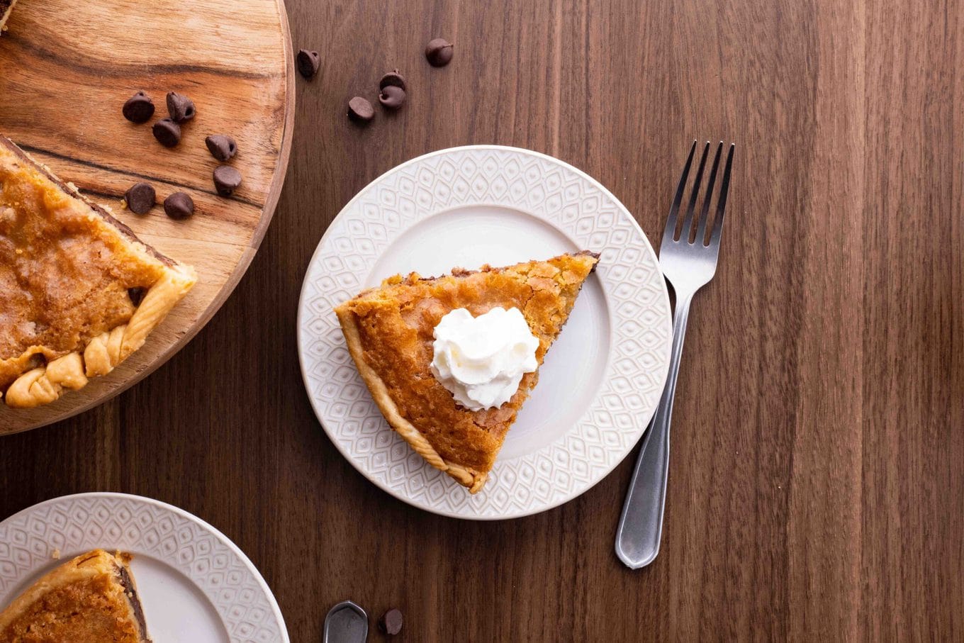 Chocolate Chip Cookie Pie slice on plate with whipped cream