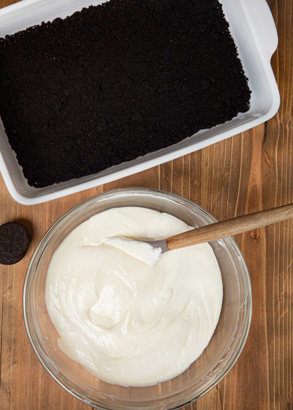 Dirt Cake Oreo crumbs in baking dish with ice cream base in bowl