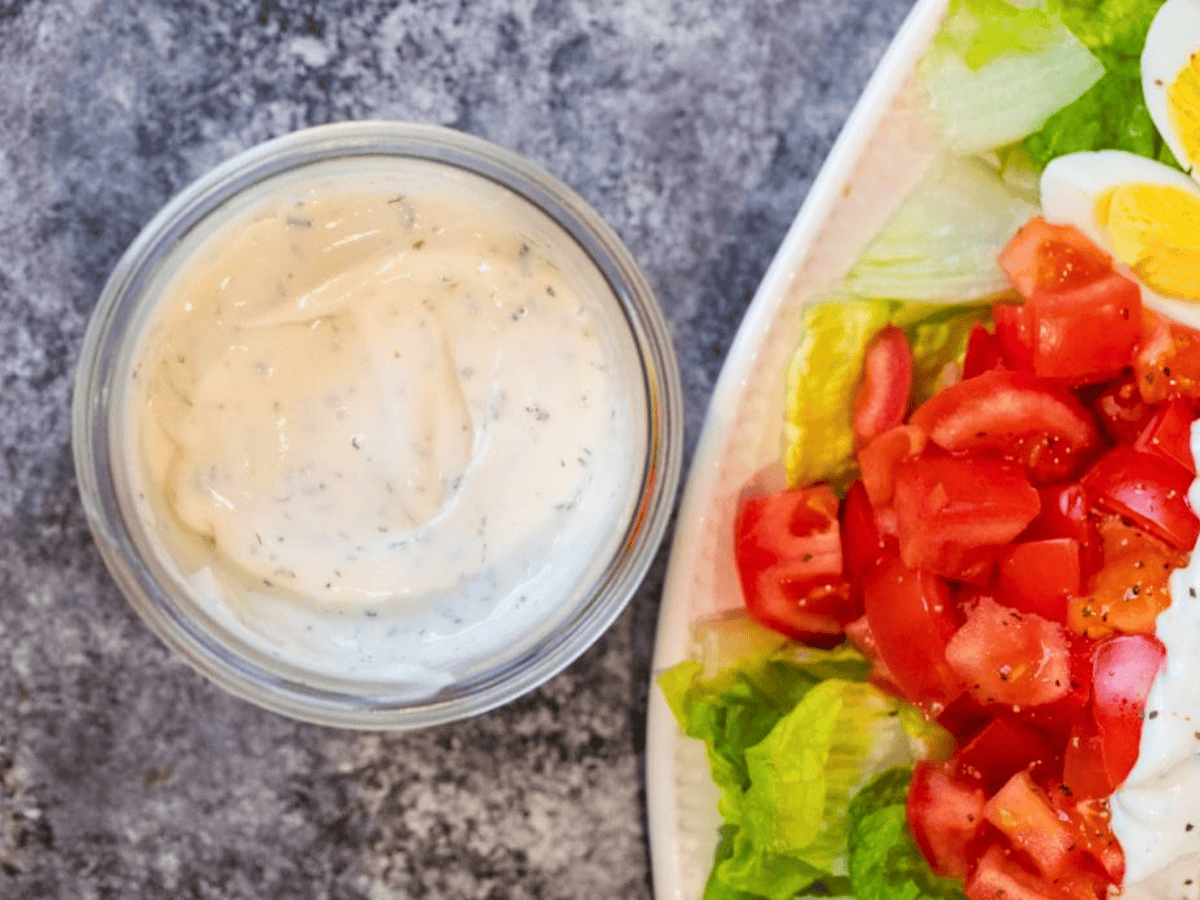 Jar of ranch next to salad