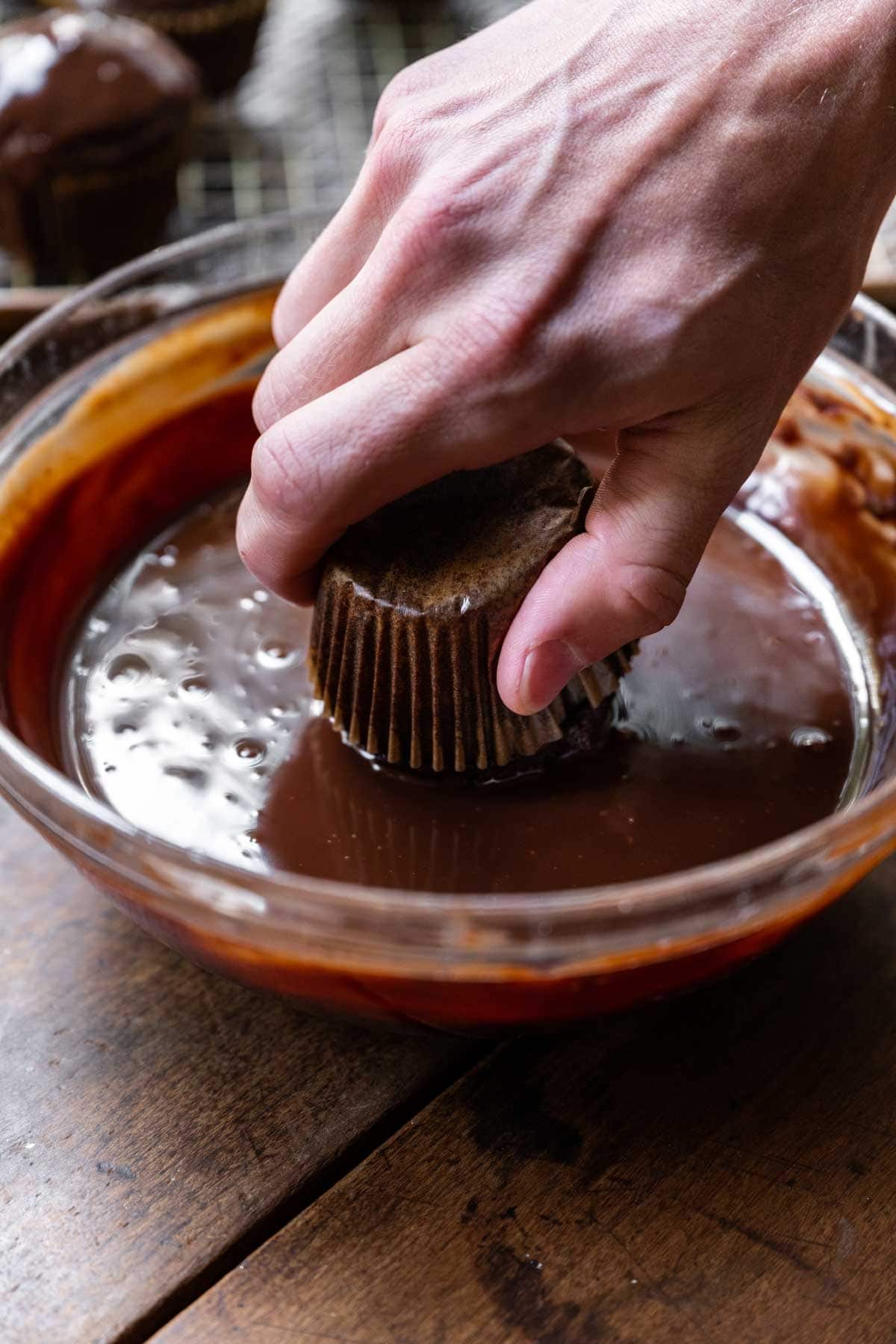 Hostess Cupcakes (Copycat) dipping cupcake into ganache