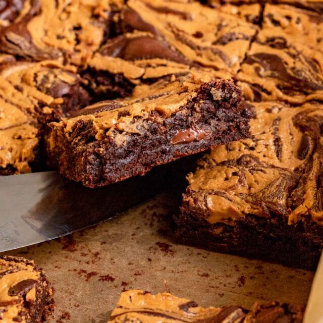Peanut Butter Swirl Brownies sliced in pan with knife