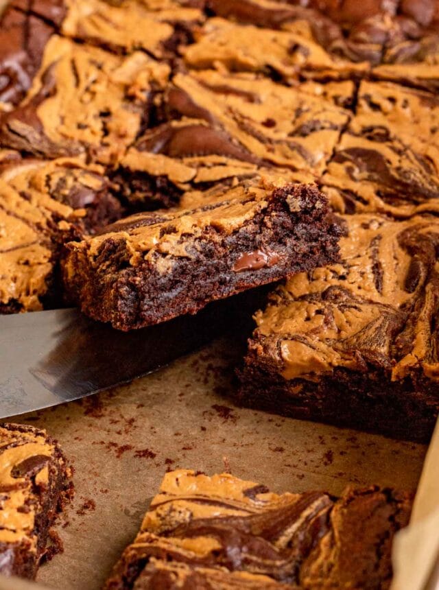Peanut Butter Swirl Brownies sliced in pan with knife