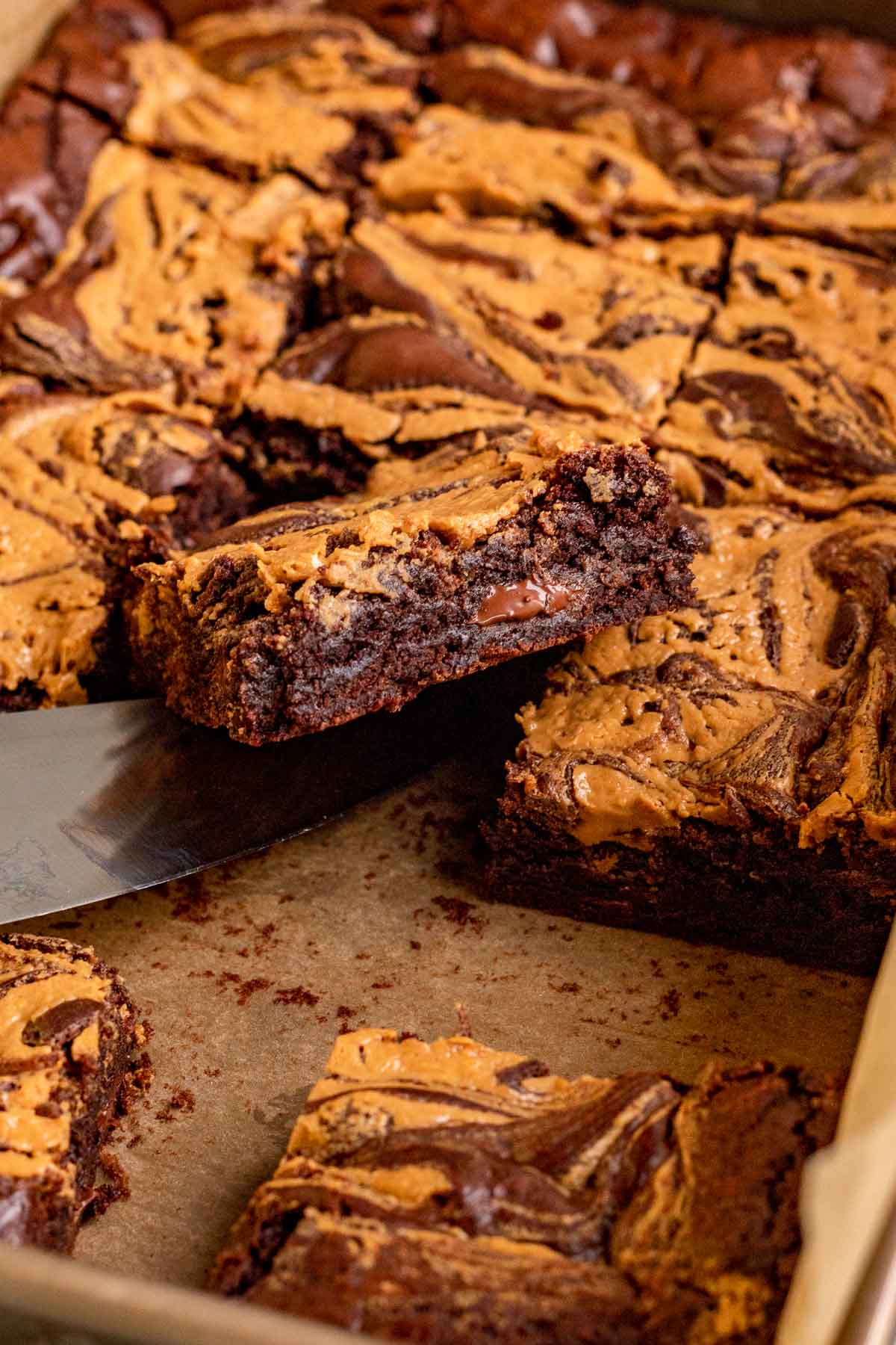 Peanut Butter Swirl Brownies sliced in pan with knife