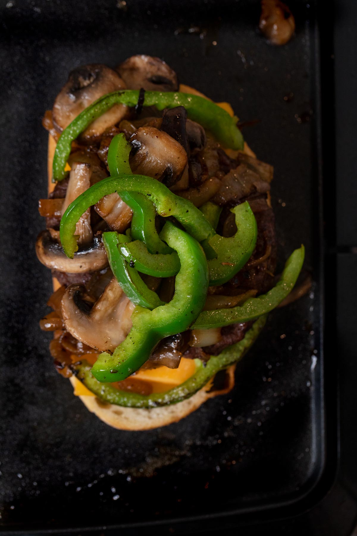 Philly Cheesesteak Patty Melt open sandwich on griddle