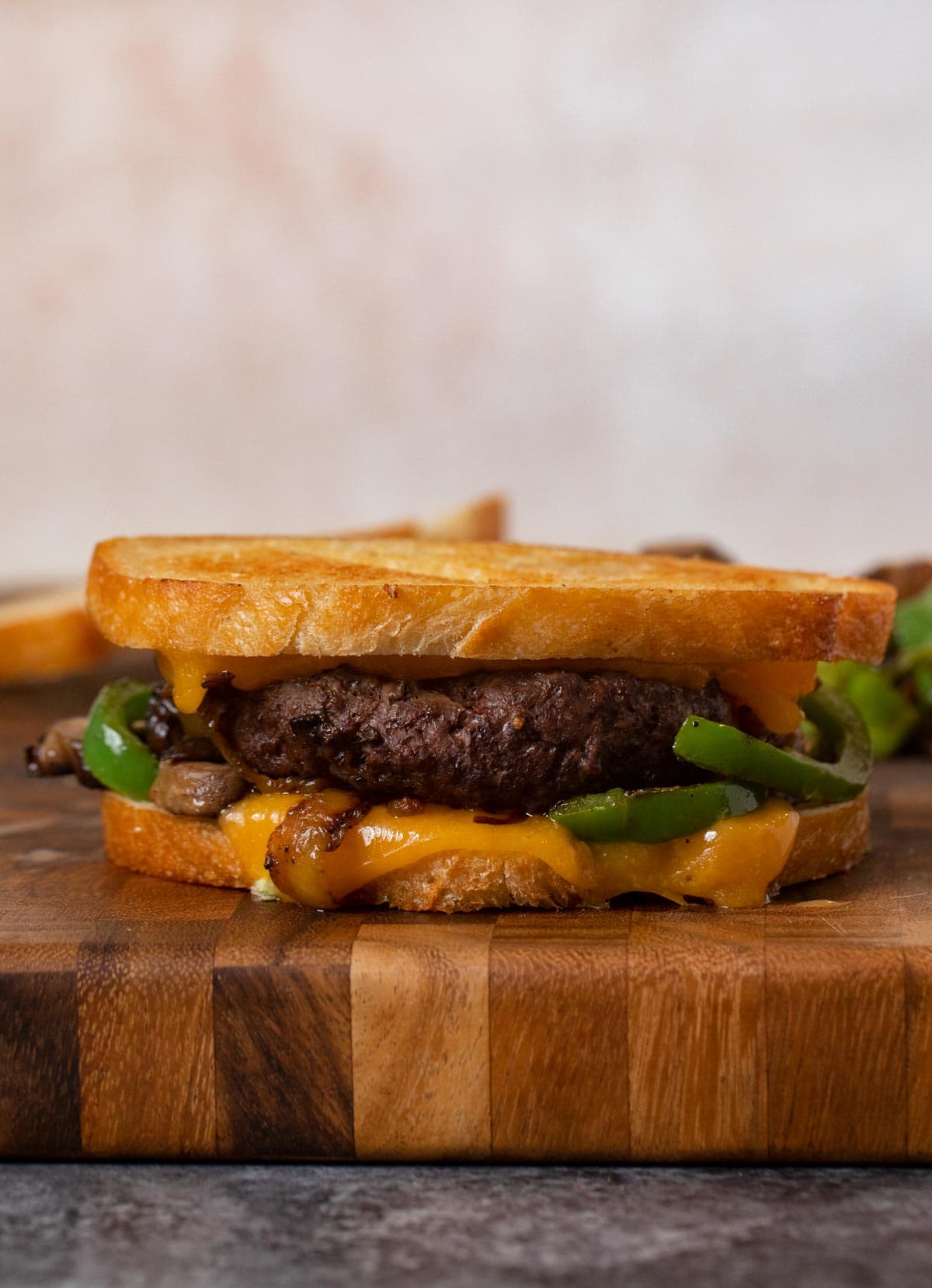 Philly Cheesesteak Patty Melt sandwich on cutting board