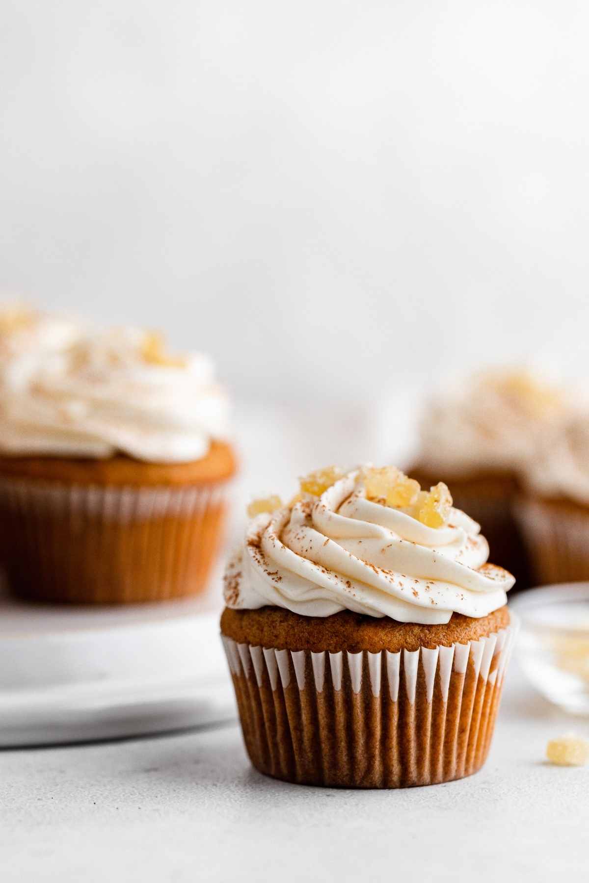 Pumpkin Ginger Cupcakes with cream cheese frosting swirl and candied ginger garnish