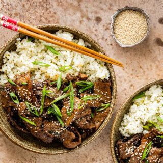 bowl of cooked beef plated over rice with chopsticks