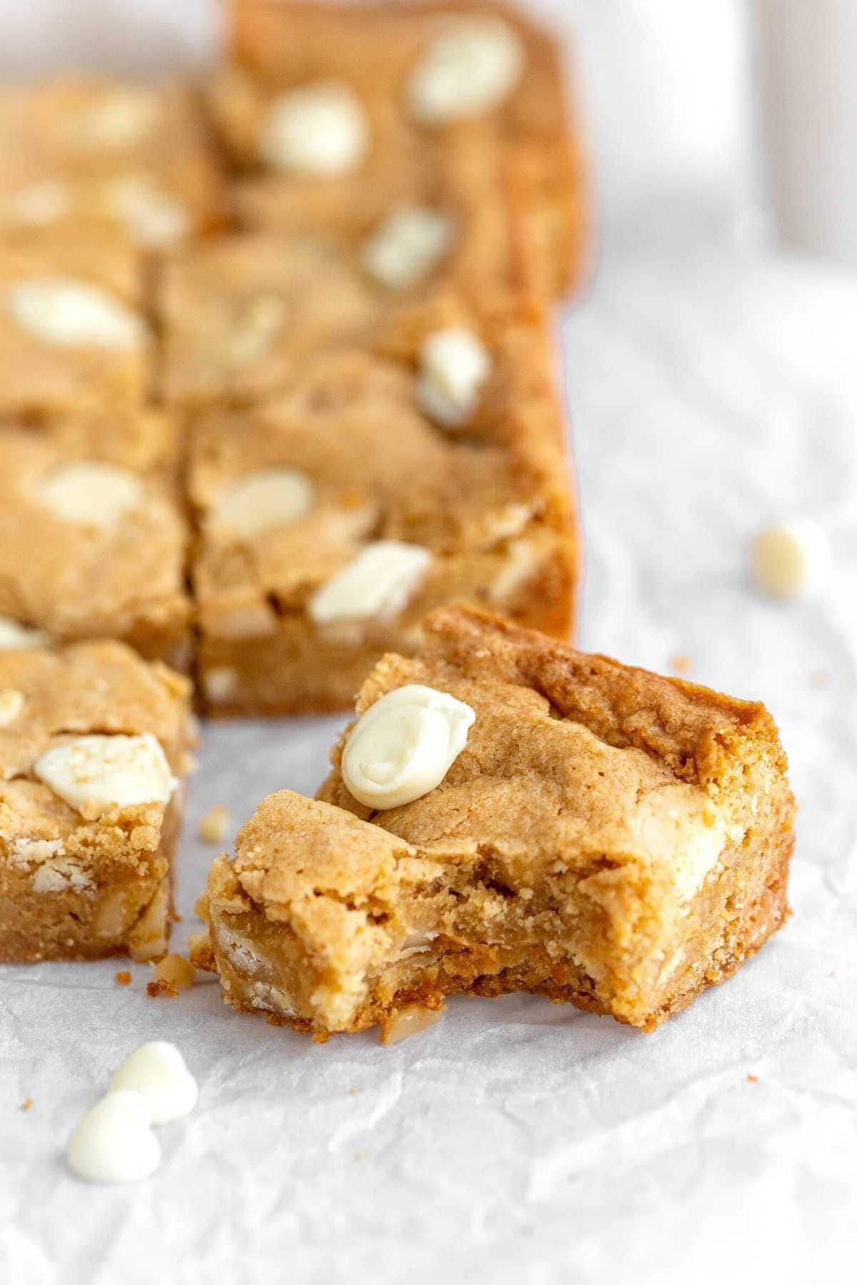 White Chocolate Macadamia Blondies cut and one blondie with bite taken out