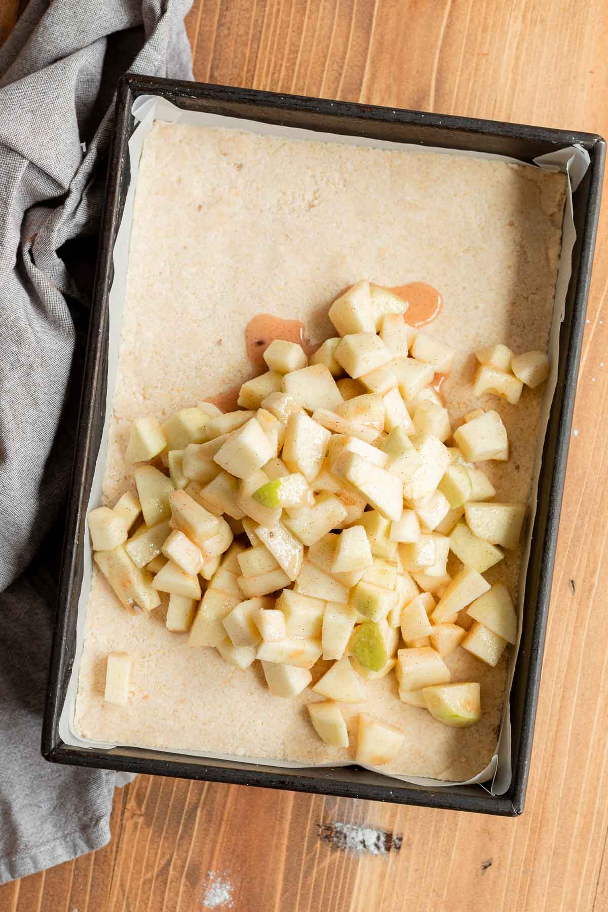 Apples and dough in pan for Apple Crumb Bars