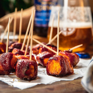 Bacon Wrapped Sweet Potatoes with toothpicks on serving board