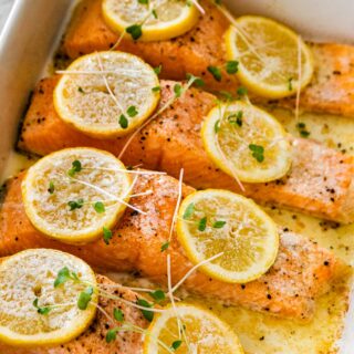Baked Salmon with Dill Sauce salmon filets in baking dish with lemon slices after baking