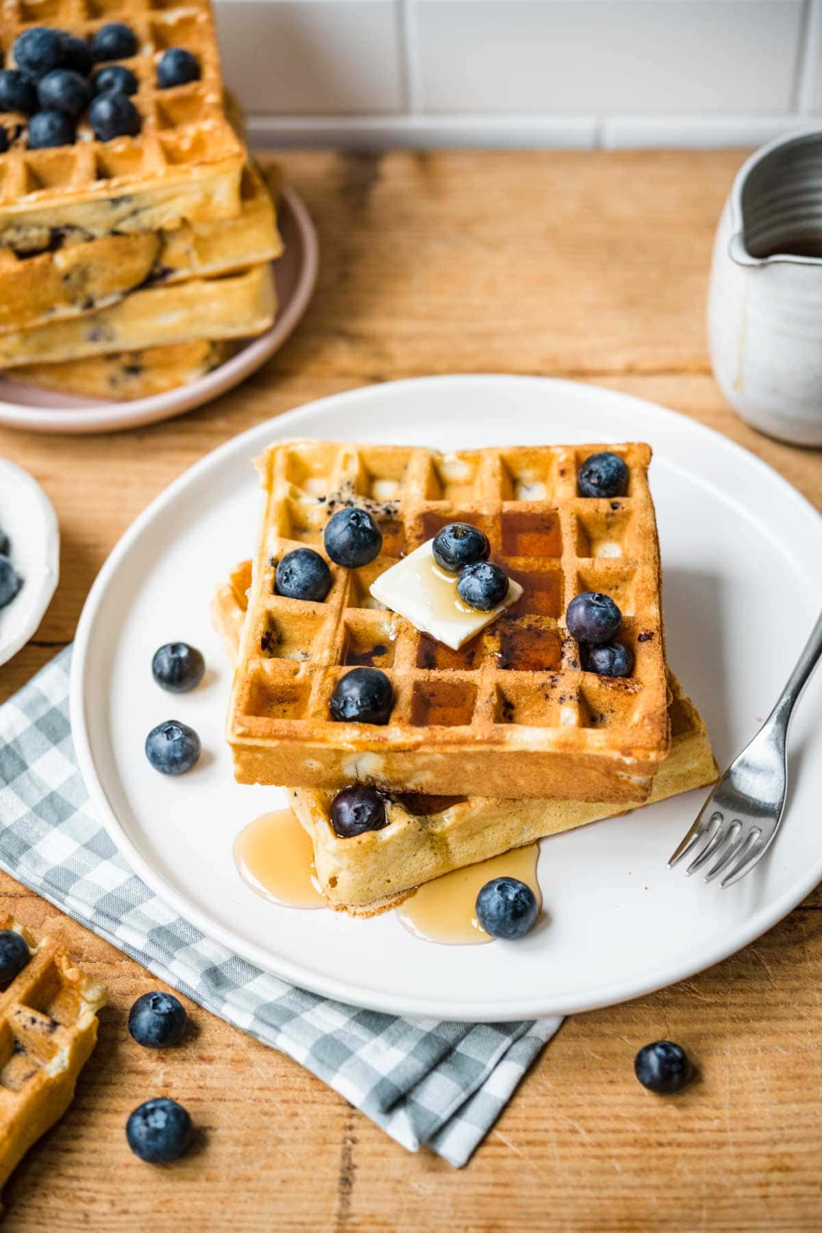 Blueberry Waffles on plate with syrup being poured