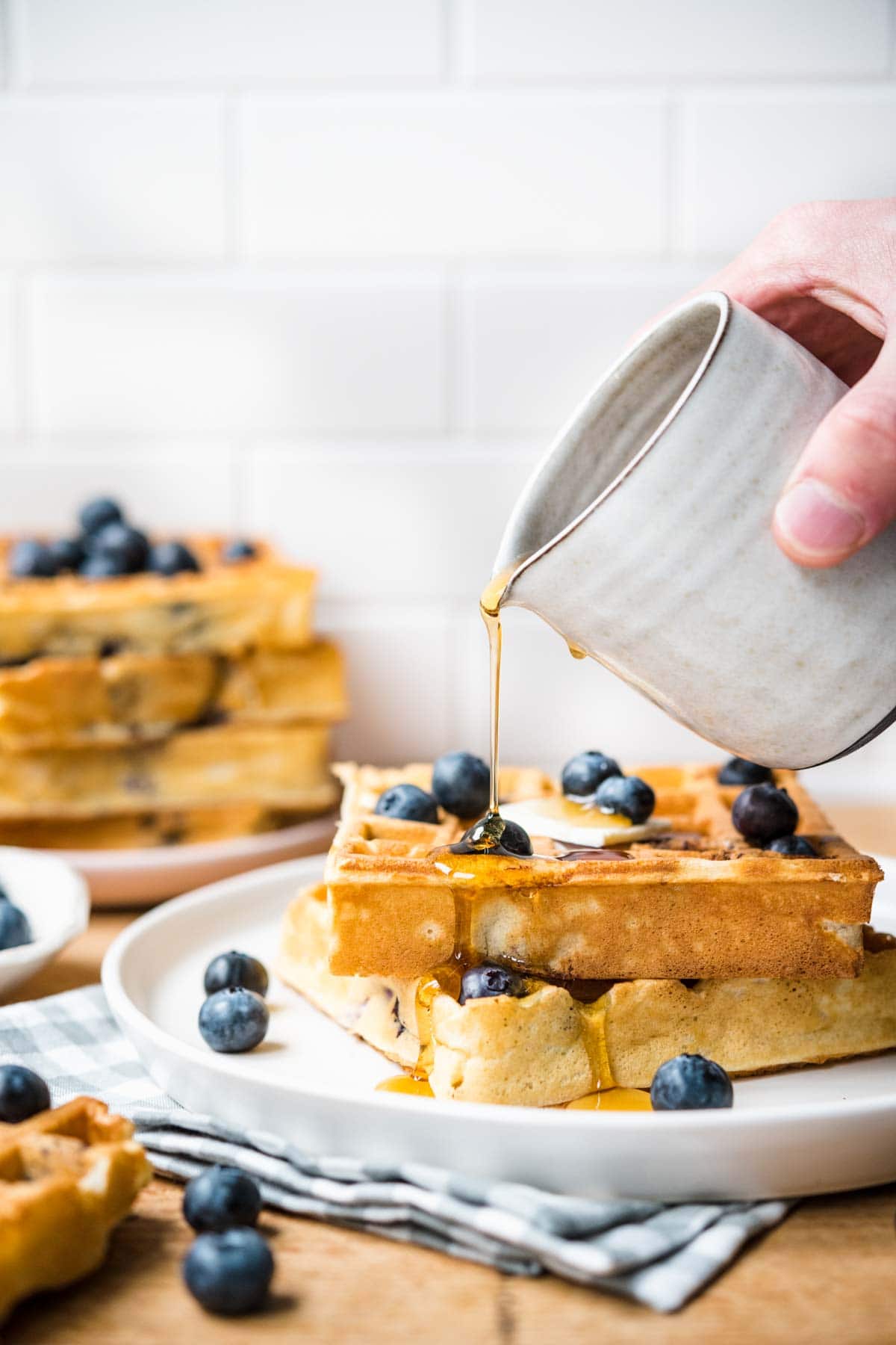 Blueberry Waffles on plate with syrup being poured