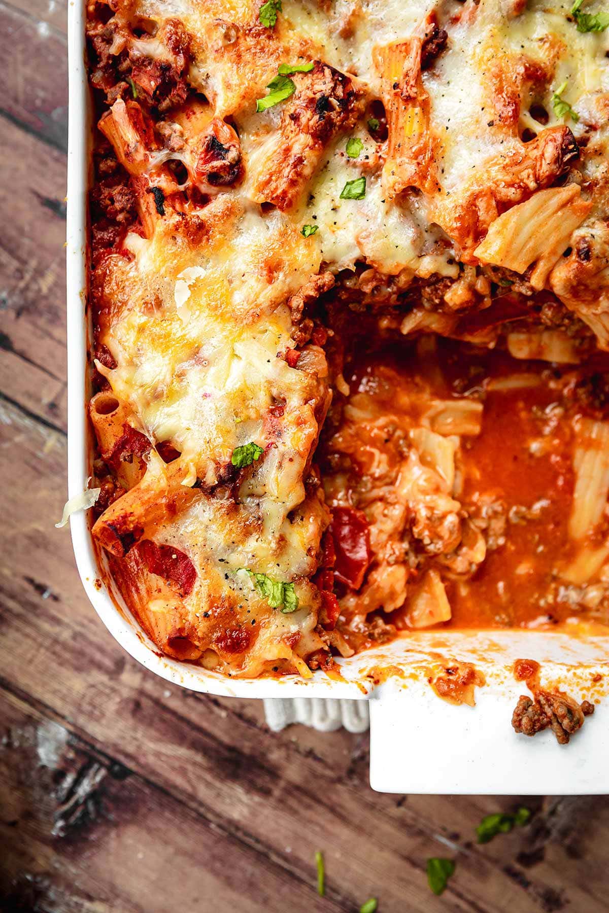 Cheesy Beef Pasta Bake in baking dish with piece missing
