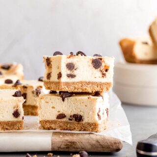 Sliced and stacked Chocolate Chip Cheesecake Bars on cutting board