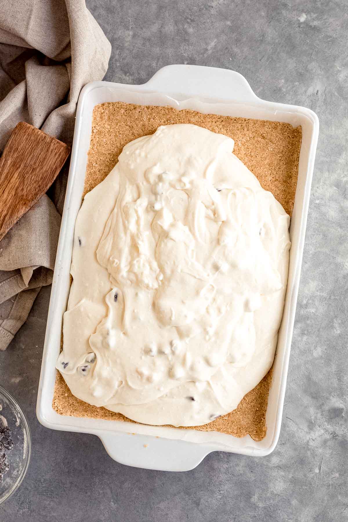 Chocolate Chip Cheesecake Bar batter added to 9x13 pan on top of graham cracker crust