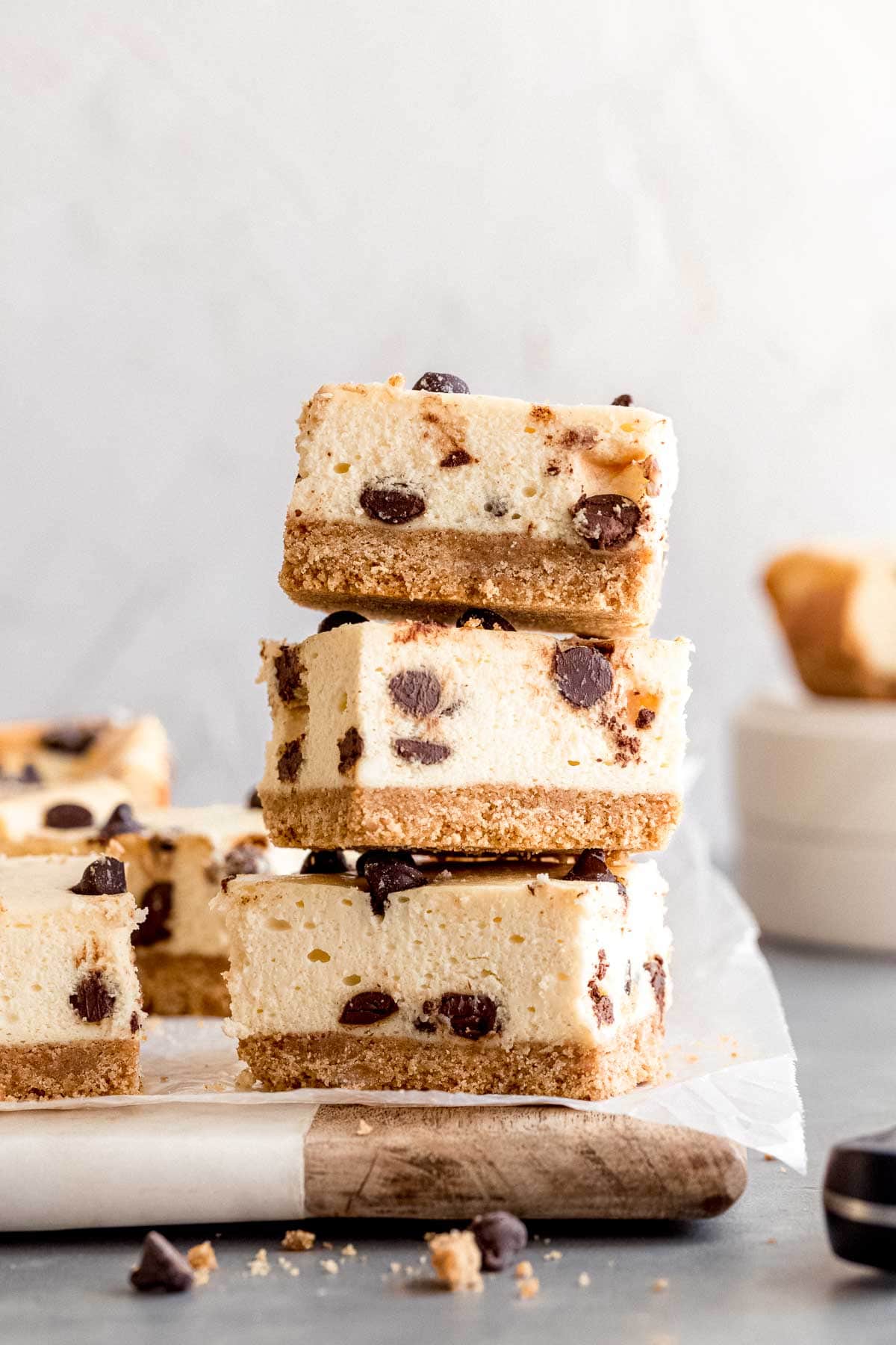 Sliced and stacked Chocolate Chip Cheesecake Bars on cutting board