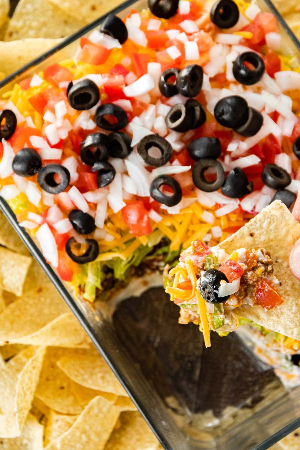 Creamy Layer Taco Dip in pan served with tortilla chips