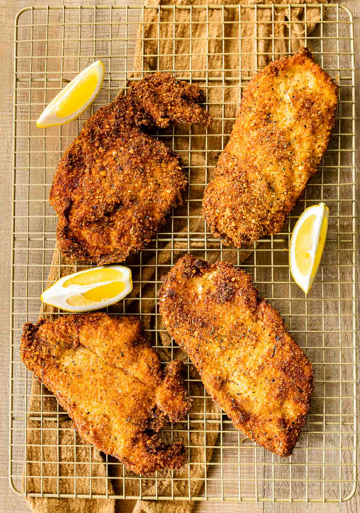 Crispy Breaded Chicken on wire rack with lemon wedges
