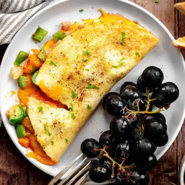 omlette on plate with grapes and fork