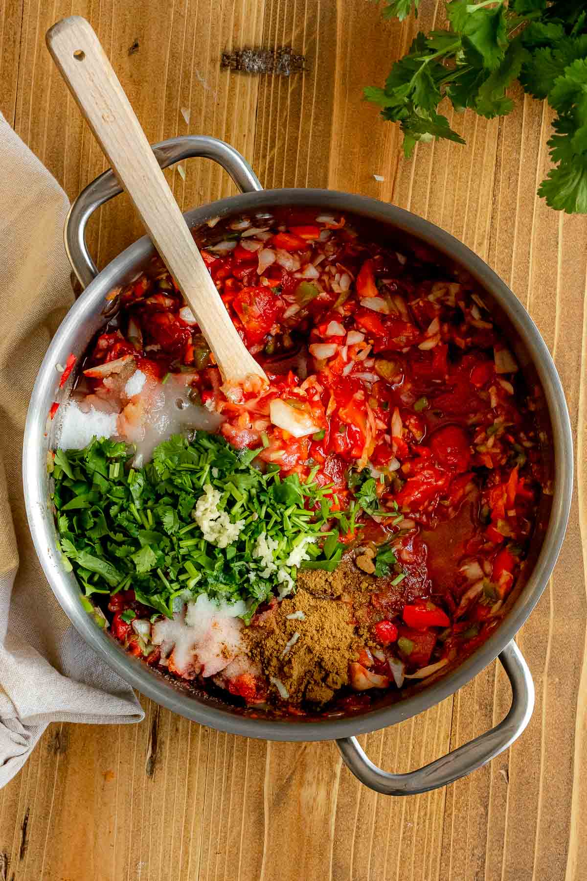 Easy Cooked Jar Salsa in pot with fresh herbs and spices added