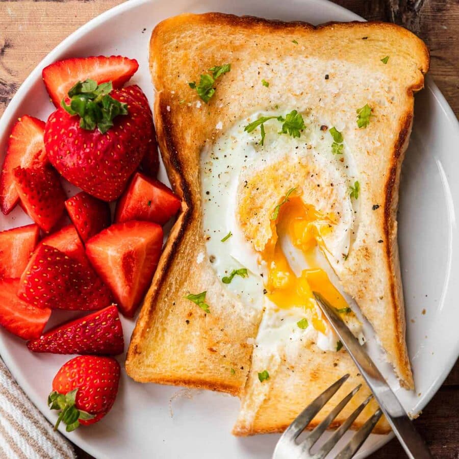 Egg in a Hole sliced open with runny egg on plate
