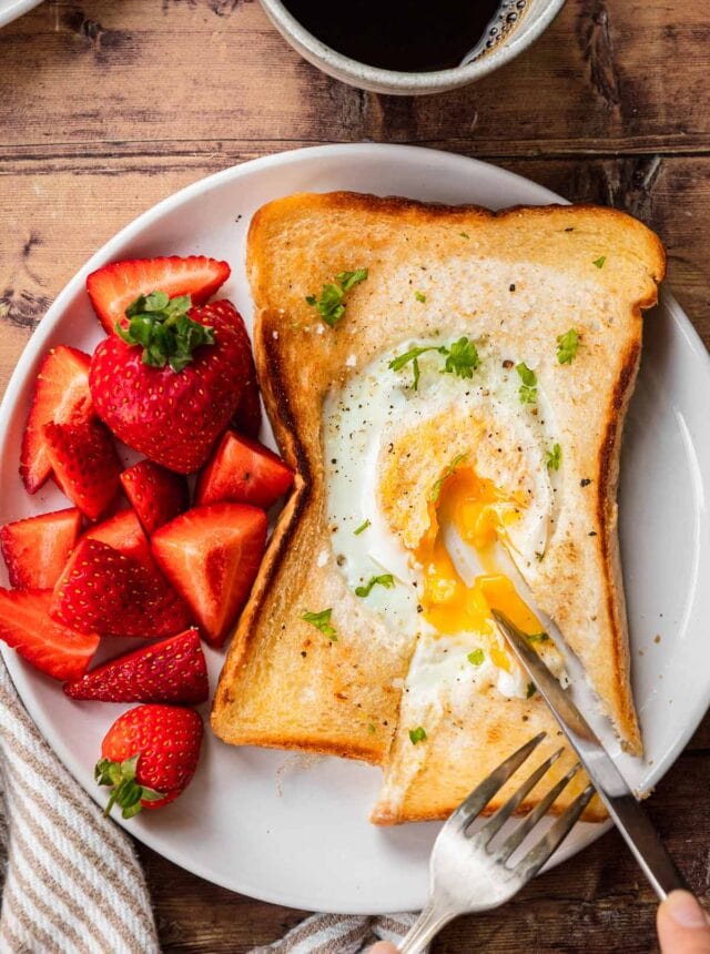 Egg in a Hole sliced open with runny egg on plate