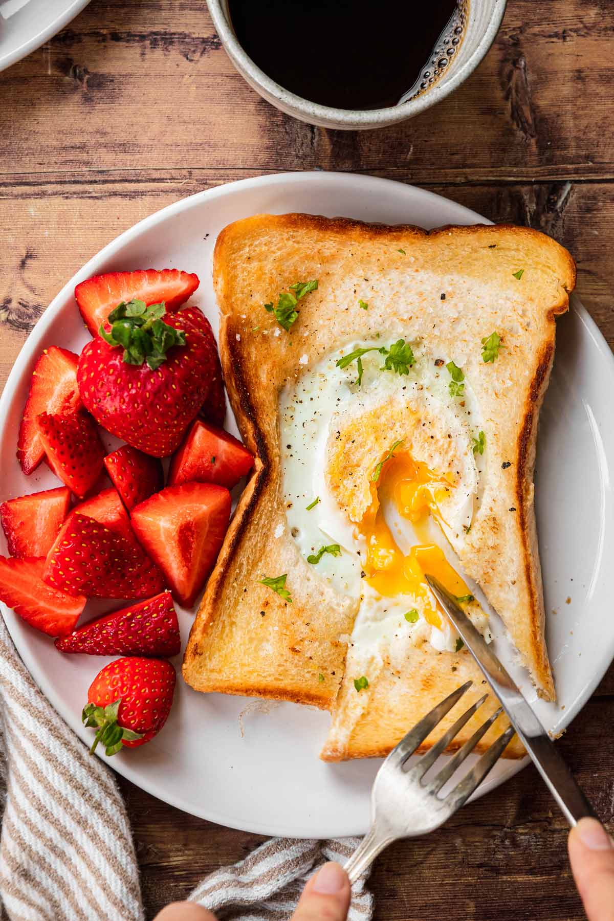 Egg in a Hole sliced open with runny egg on plate