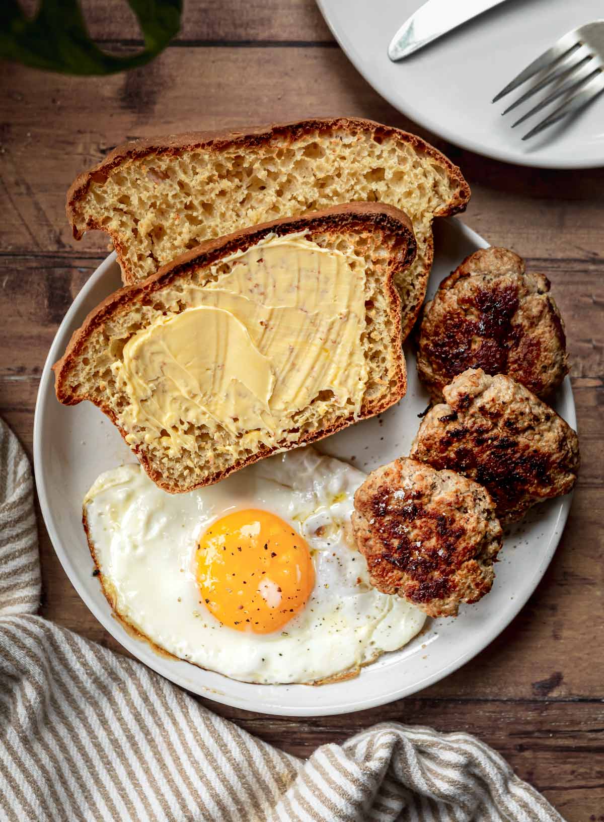 English Muffin Bread slices on plate with butter and breakfast