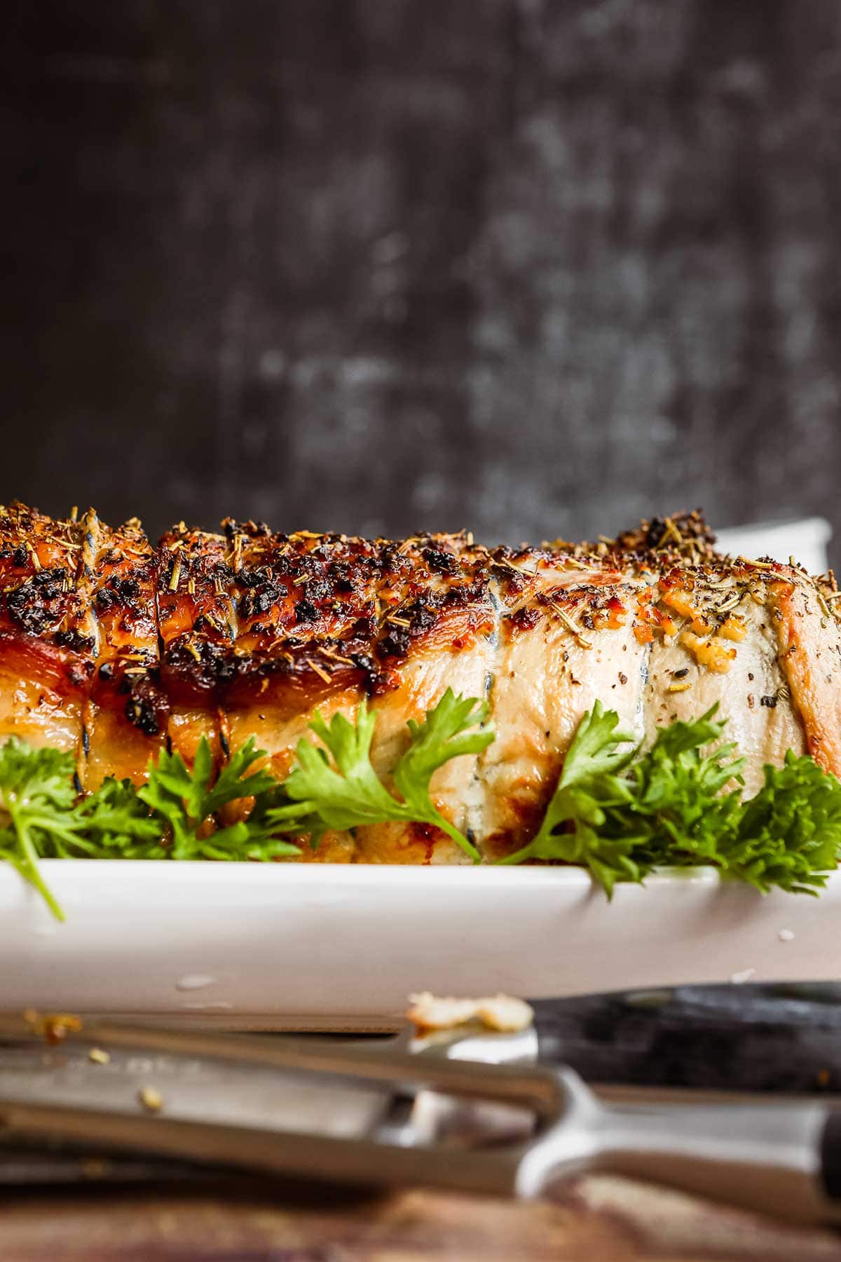 Herb Crusted Pork Loin on platter with parsley garnish