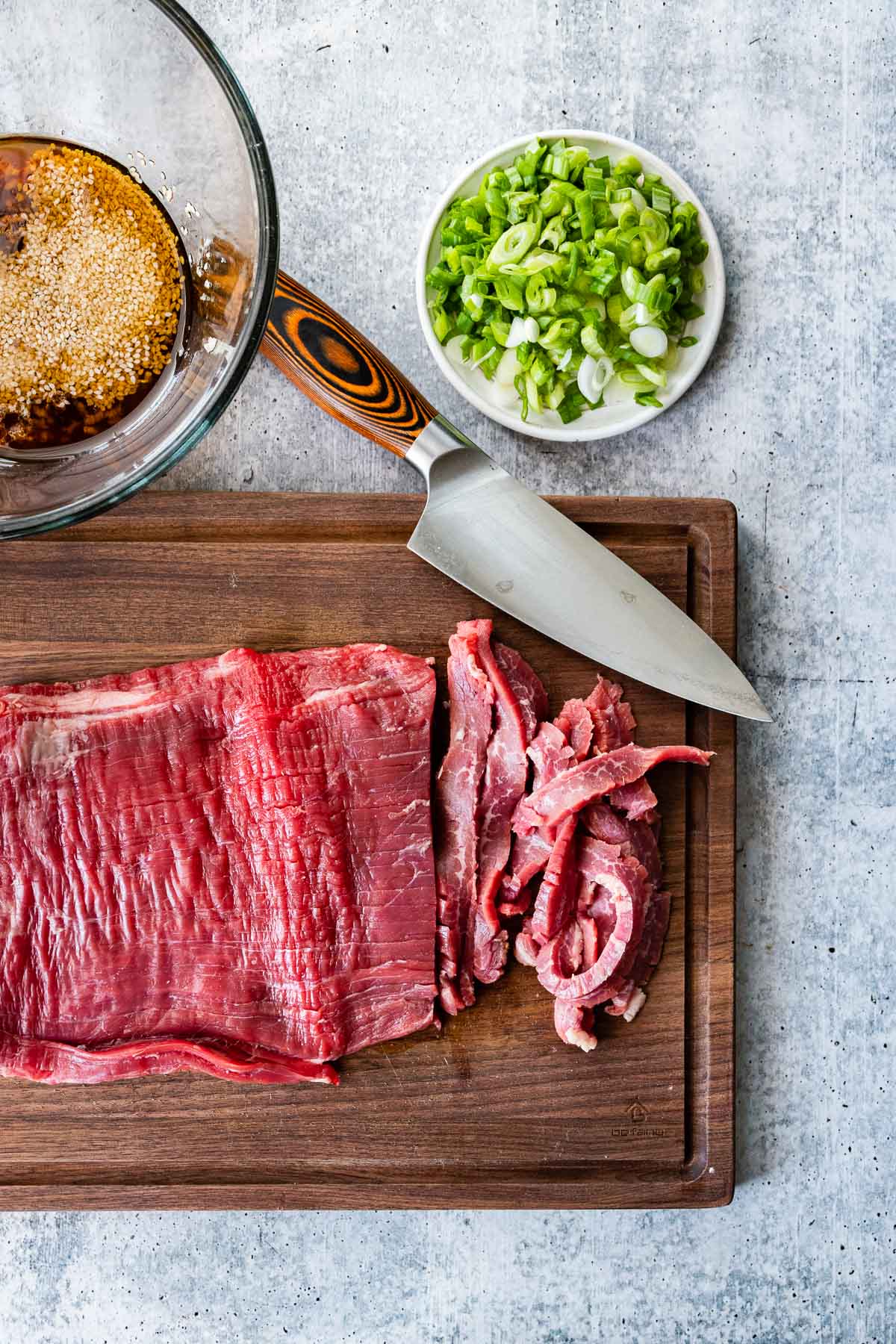 Korean Beef Bulgogi raw flank steak being sliced thin