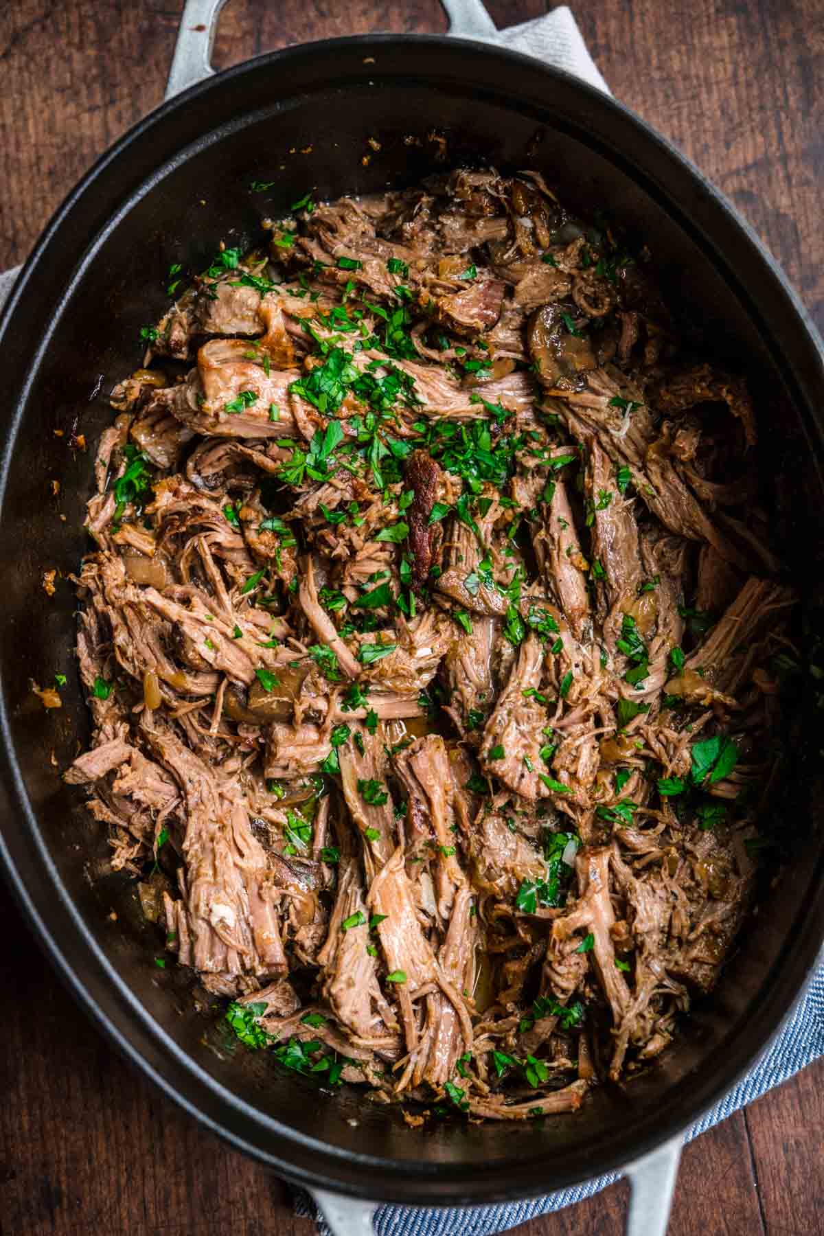 Mushroom Beef Roast shredded and garnished with fresh parsley