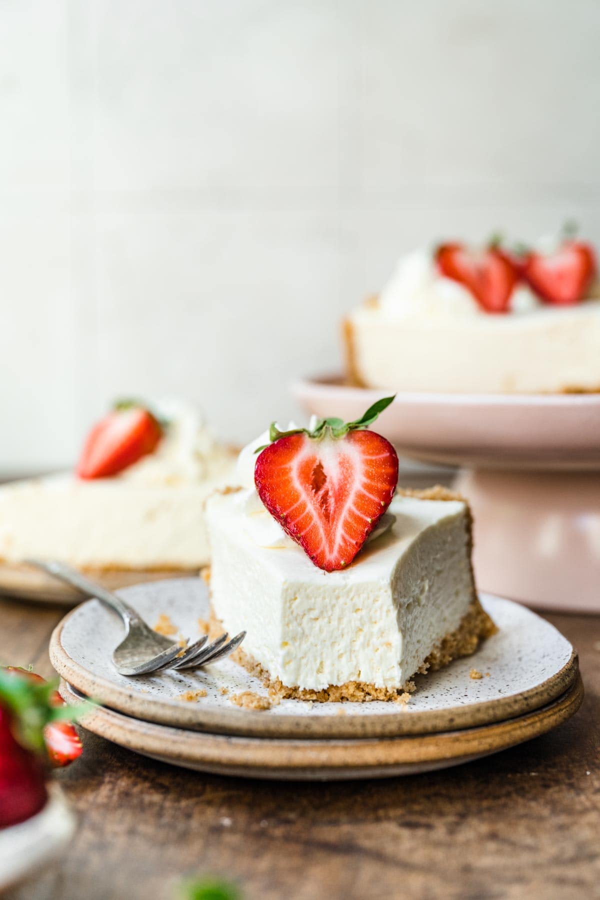 No-Bake Cheesecake sliced with fresh strawberry garnish on plate with fork