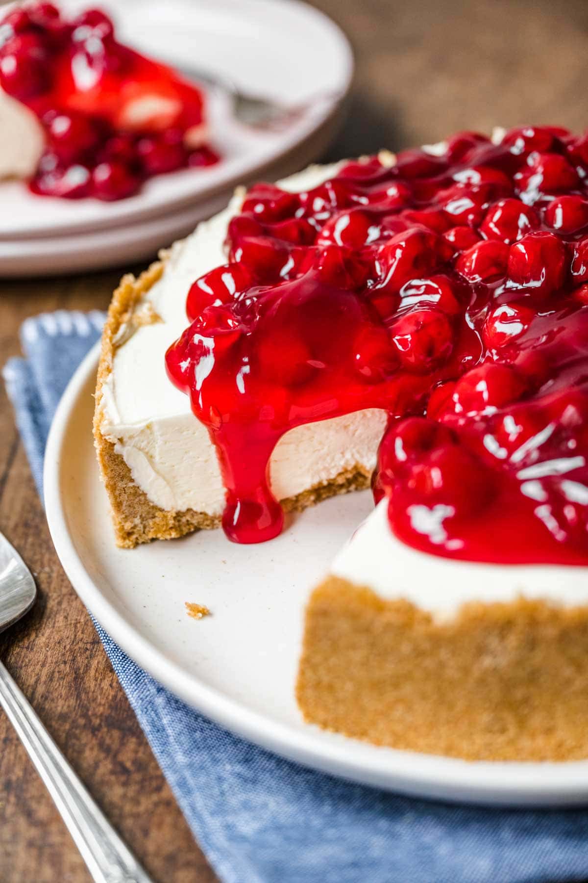 No Bake Cherry Cheesecake on serving plate with slice removed