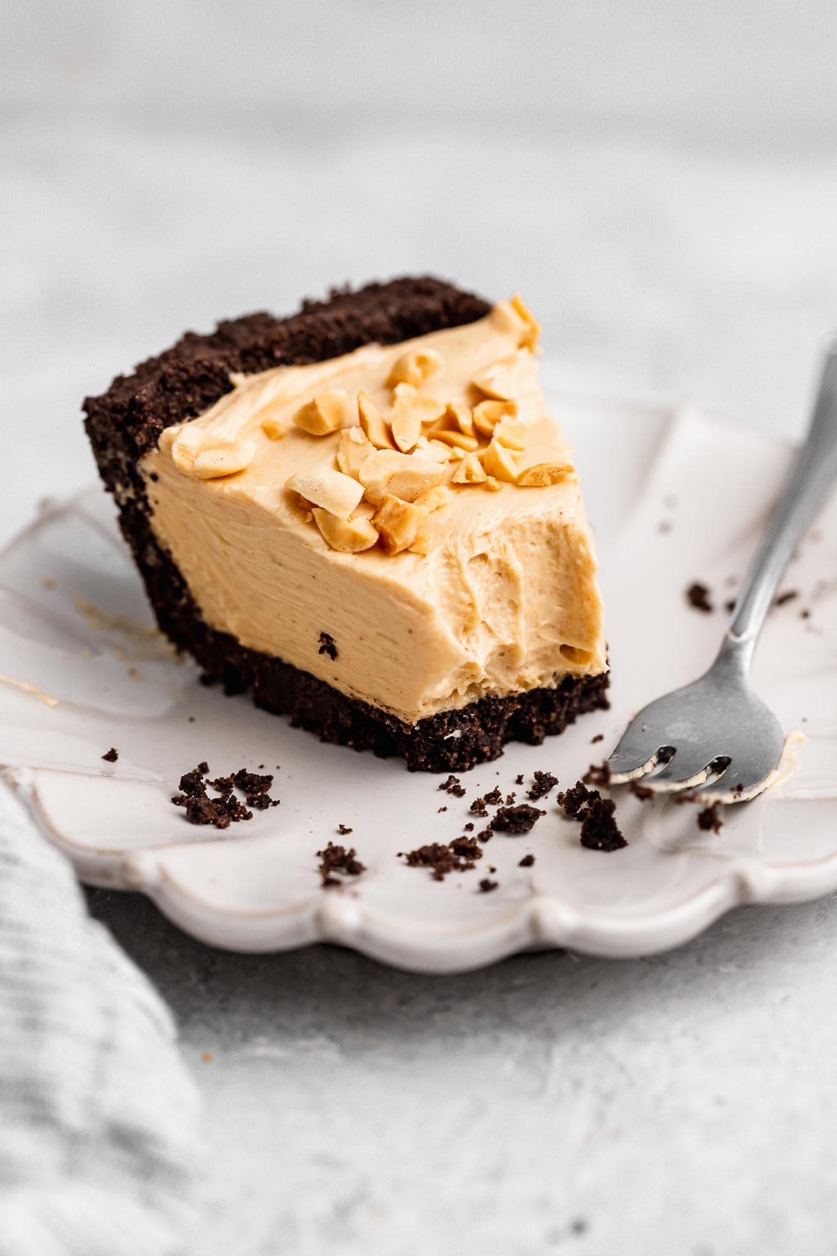 Oreo Peanut Butter Whip Pie slice on plate with fork and bite missing