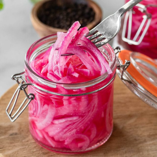Pickled Red Onions in jar on cutting board