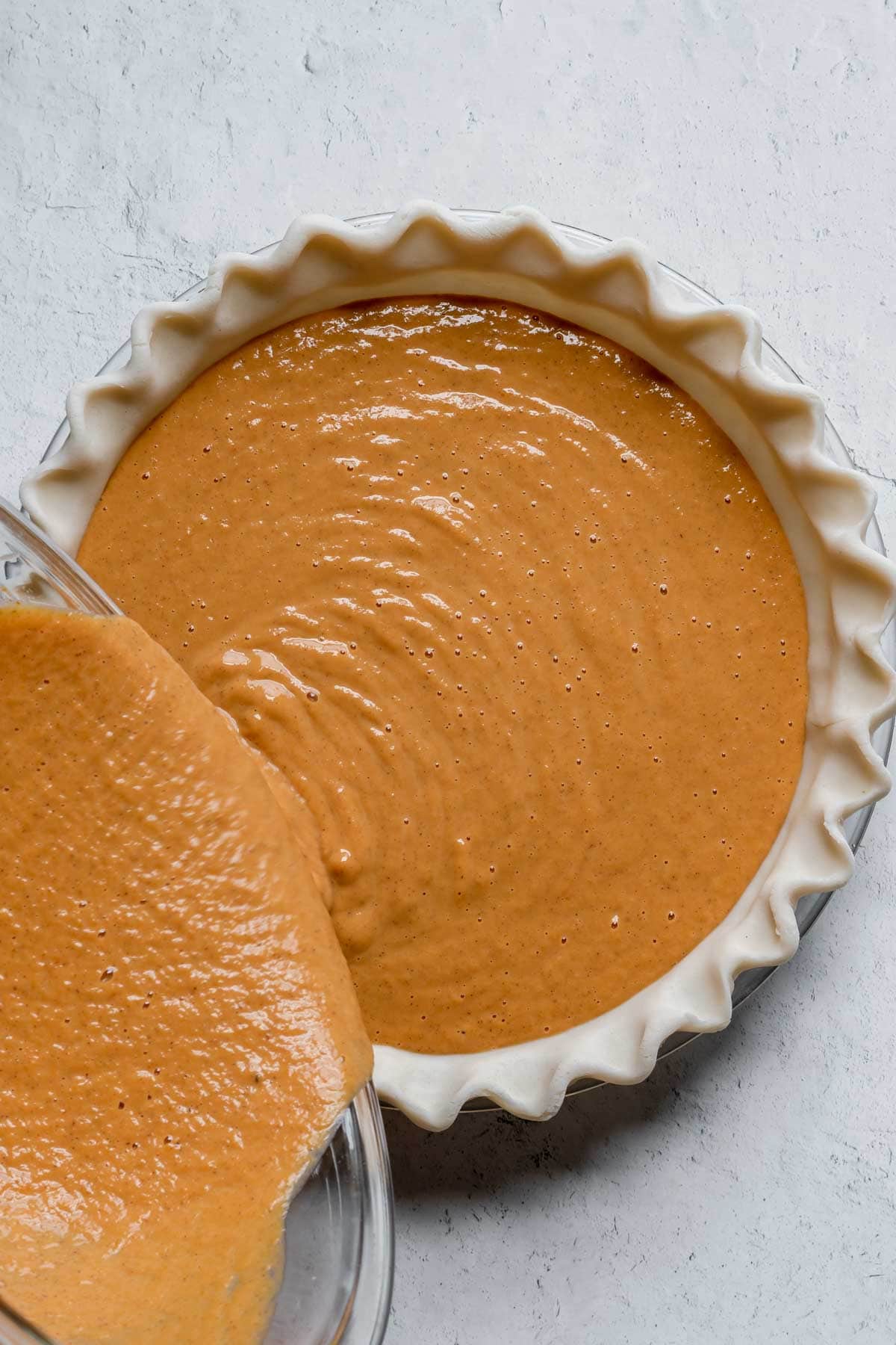 5 Ingredient Pumpkin Pie filling being poured into crust