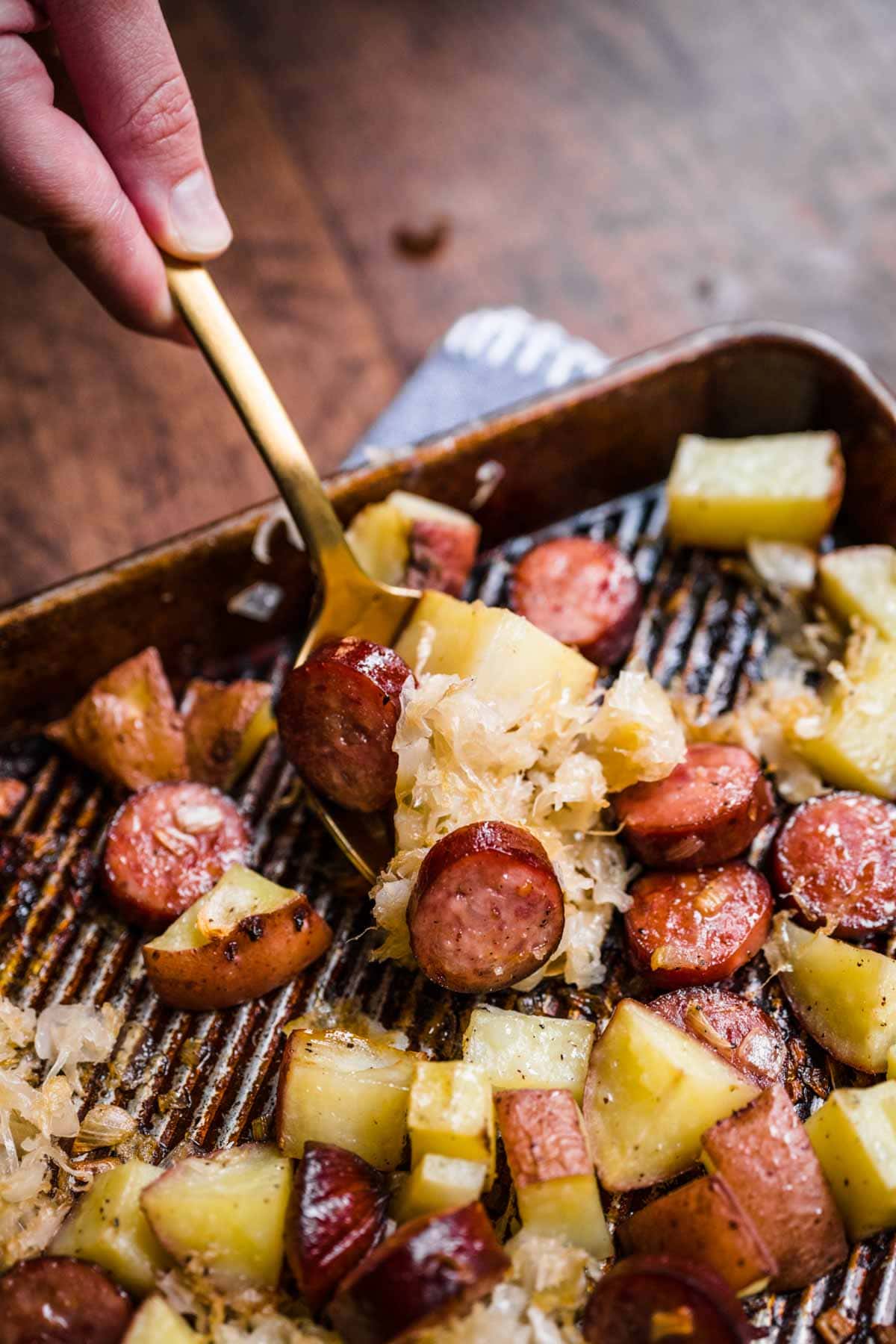 Sheet Pan Sausage and Sauerkraut on spoon closeup